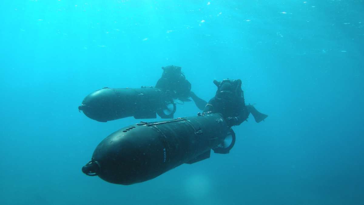 "Binôme de nageurs de combat du commando Hubert progressant sous l'eau à l'aide d'un tracteur sous-marin". © Commando Hubert